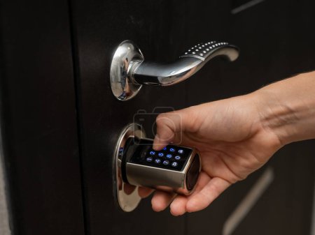 Woman opens the combination lock on the door to the apartment. Keyless entry