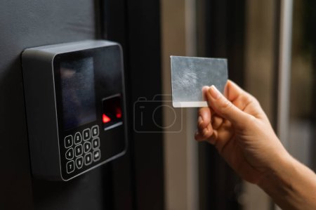 Foto de Una mujer abre la puerta con una tarjeta de plástico. Cerradura de entrada sin llave moderna - Imagen libre de derechos