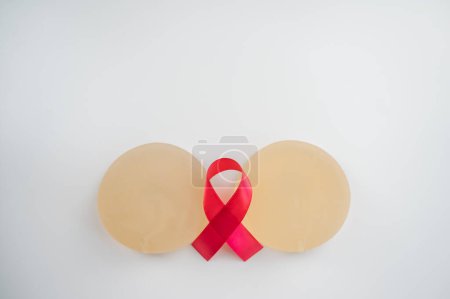 Foto de Implantes mamarios y cinta de satén. Símbolo de conciencia del cáncer de mama - Imagen libre de derechos