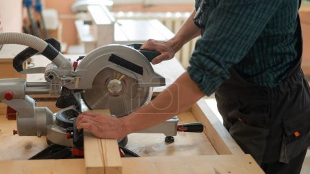 Photo for Master cuts the board with a circular saw in the workshop - Royalty Free Image