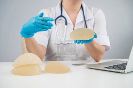 Photo for Doctor plastic surgeon explains the benefits of different breast implants - Royalty Free Image