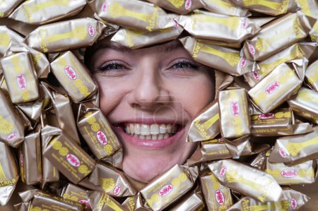 Photo for The face of a caucasian woman surrounded by Rakhat chocolates - Royalty Free Image