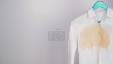 Foto de Camisa blanca de oficina para mujer con una mancha de café sobre fondo blanco. Copiar espacio - Imagen libre de derechos