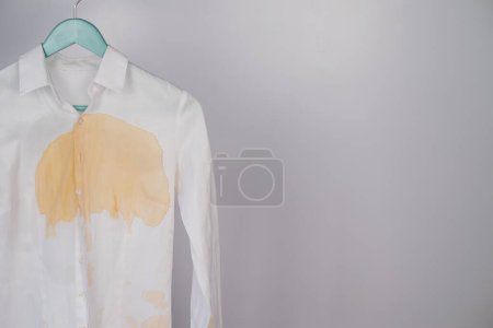 Foto de Camisa blanca de oficina para mujer con una mancha de café sobre fondo blanco. Copiar espacio - Imagen libre de derechos