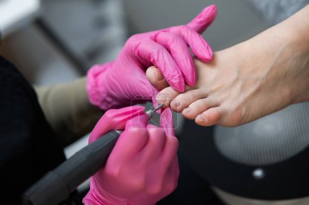 Photo for The master makes hardware pedicures to the client. Cuticle treatment - Royalty Free Image