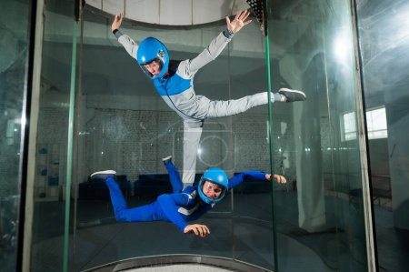 Foto de Un hombre y una mujer disfrutan volando juntos en un túnel de viento. Simulador de caída libre. - Imagen libre de derechos