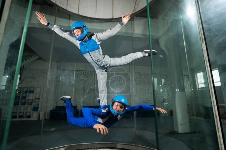 Photo for A man and a woman enjoy flying together in a wind tunnel. Free fall simulator. - Royalty Free Image