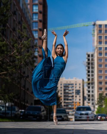 Téléchargez les photos : Belle ballerine asiatique dansant en plein air. Paysage urbain - en image libre de droit