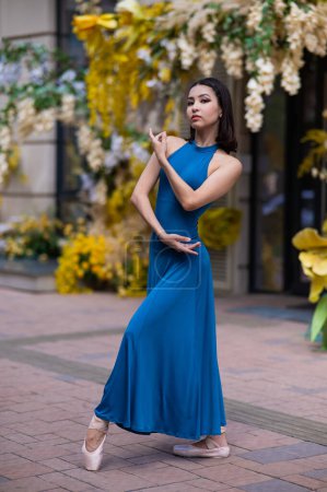 Téléchargez les photos : Belle ballerine asiatique posant sur le fond d'un bâtiment décoré de fleurs - en image libre de droit