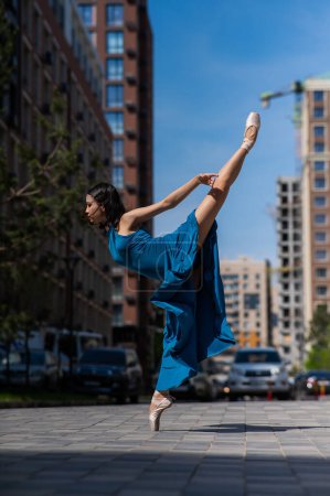Foto de Hermosa bailarina asiática bailando al aire libre. Paisaje urbano - Imagen libre de derechos