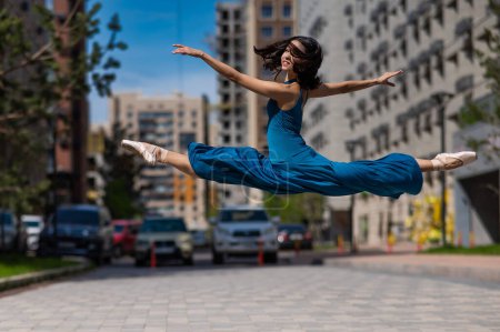 Foto de Hermosa bailarina asiática bailando al aire libre. Paisaje urbano. Gran jete - Imagen libre de derechos