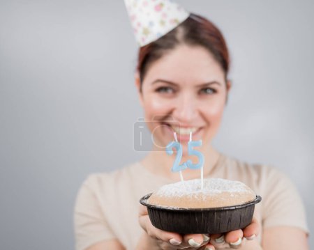 Foto de La mujer feliz pide un deseo y sopla las velas en el pastel de cumpleaños 25. Chica celebrando cumpleaños - Imagen libre de derechos