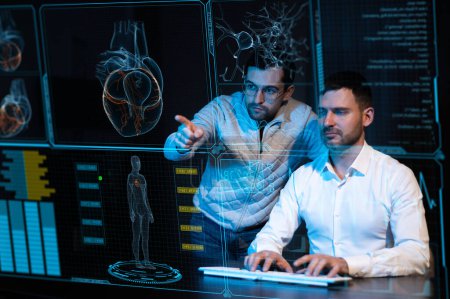 Téléchargez les photos : Deux hommes barbus caucasiens regardent et discutent des données sur l'écran médical du menu virtuel. Lectures sur le moniteur de survie - en image libre de droit