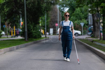 Mujer embarazada ciega caminando por la calle con un bastón