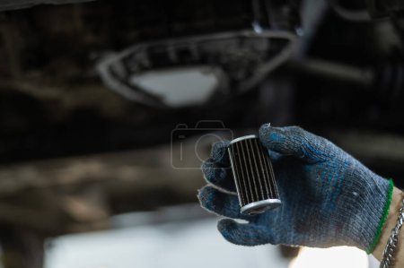 Photo for A mechanic replaces the fine filter for the transmission oil. Car on a lift in a car service center - Royalty Free Image