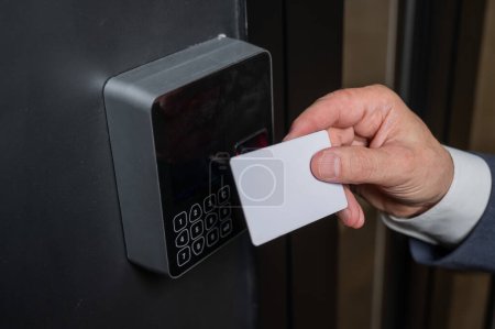 Foto de Un hombre abre la puerta con una tarjeta. Cerradura electrónica moderna. Entrada sin llave. - Imagen libre de derechos