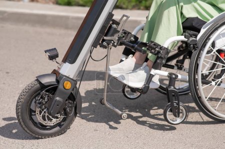 Foto de Una mujer en silla de ruedas con un dispositivo de asistencia para el control manual. Handbike eléctrico - Imagen libre de derechos