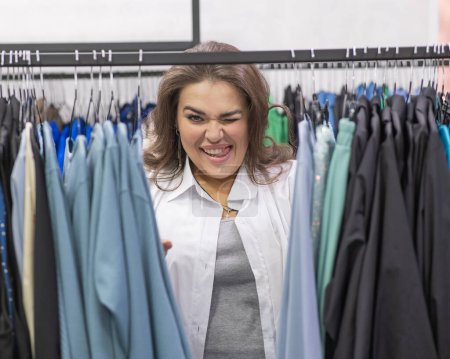 Téléchargez les photos : Sourire femme grosse dans plus magasin de taille en regardant la caméra - en image libre de droit