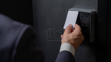 Téléchargez les photos : Un homme ouvre la porte avec une carte. Serrure électronique moderne. Entrée sans clé. - en image libre de droit