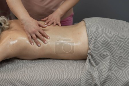 Téléchargez les photos : Femme ayant un massage thérapeutique du dos - en image libre de droit
