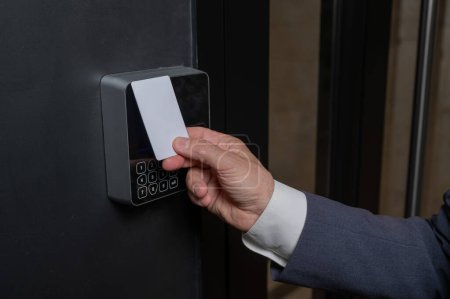 A man opens the door with a card. Modern electronic lock. Keyless Entry. 