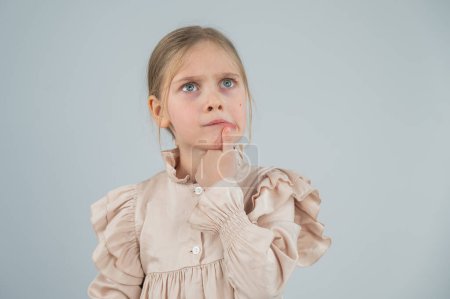 Porträt eines niedlichen kaukasischen nachdenklichen Mädchens auf weißem Hintergrund