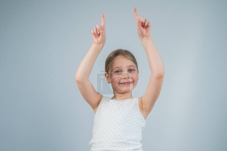 Little Caucasian girl having fun and pointing with fingers on white background