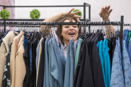 Porträt einer dicken Frau im Plus-Size-Laden durch Kleiderbügel