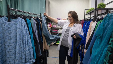 Eine dicke Frau wählt Kleidung in einem Plus-Size-Laden