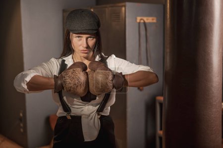 A woman posing with boxing gloves. Retro style Peaky Blinders