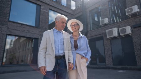 An elderly couple in love walks through the city