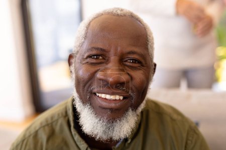 Close-up portrait of smiling bearded african american senior man in nursing home. Happy, face, unaltered, support, assisted living and retirement concept.