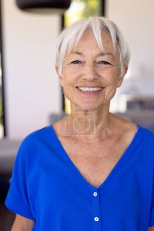 Close-up portrait of cheerful asian senior woman with short hair in nursing home against wall. Copy space, happy, wrinkles, face, unaltered, support, assisted living and retirement concept.