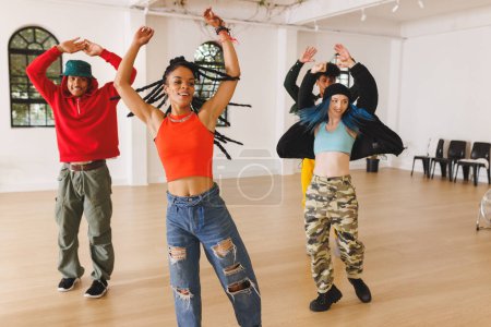 Bild einer Gruppe verschiedener weiblicher und männlicher Hip-Hop-Tänzer, die im Tanzstudio üben. Tanz, Rhythmus, Bewegung und Trainingskonzept.
