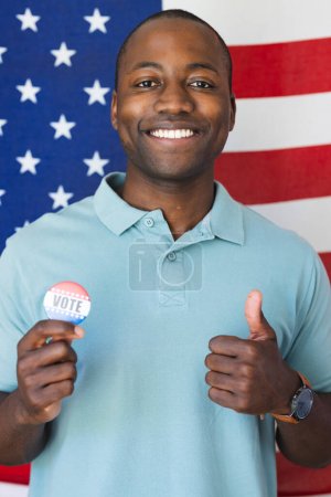 Young African American man shows his support for democracy with a 'vote' badge. He proudly displays this badge, encouraging civic participation.