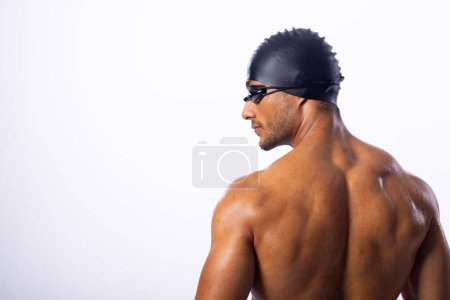 Young biracial male swimmer wearing swimming goggles. His athletic build and focused look suggest preparation for a competitive swim.