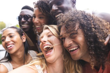Diversos grupos de amigos comparten un momento alegre, riéndose juntos al aire libre. Sus sonrisas genuinas y su cercanía sugieren un fuerte vínculo y felicidad.