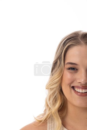 Plus-size Caucasian female with blonde hair smiles on white background, copy space. She wears a sleeveless top, light makeup, and exudes happiness and confidence, unaltered