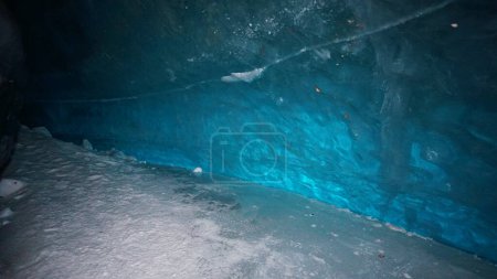 Photo for A huge corridor inside an ice cave in the mountains. The turquoise color of the ice gives a special atmosphere. There is snow on the icy floor. Clean walls of ice let in light. Tons of ice. - Royalty Free Image