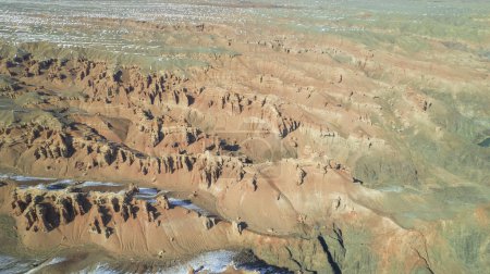 Téléchargez les photos : Charyn Grand Canyon aux parois rocheuses orange. Vue aérienne depuis le drone des parois abruptes du canyon, des fissures et des tunnels. Il y a de la neige par endroits. Le soleil brille de mille feux. Frère du Grand Canyon - en image libre de droit
