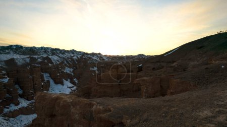 Téléchargez les photos : Charyn Grand Canyon aux parois rocheuses orange. Vue aérienne depuis le drone des parois abruptes du canyon, des fissures et des tunnels. Il y a de la neige par endroits. Beau coucher de soleil et lever de soleil. Frère du Grand Canyon - en image libre de droit