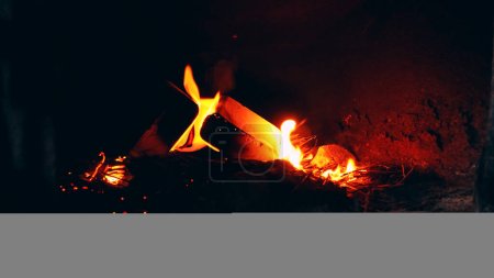 Photo for A fire is burning in an old stove in the wall. Rusty metal on the door, damp frozen gray walls. Garbage on the floor. An abandoned hut and a former prison. - Royalty Free Image