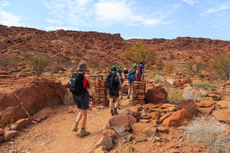 Téléchargez les photos : Twyfelfontein, Damaraland, Namibia - 05 October 2018: Tourists in Twyfelfontein, site of ancient rock engravings in the Kunene Region of north-western Namibia. Prehistoric Bushman engravings, rock painting. - en image libre de droit