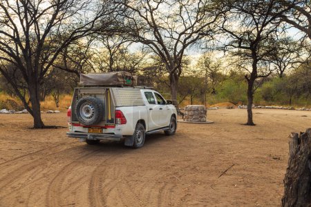 Foto de Etosha National Park 05 October 2018: Equipment car on Onguma Bush Camp. Camping Area. Buildings with thatched roofs. - Imagen libre de derechos