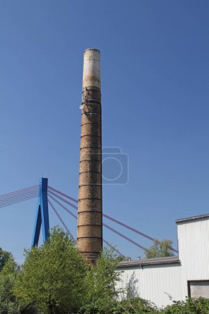 Photo for Chimney of the old Hockenheim brickworks with the Rhine bridge in the background - Royalty Free Image