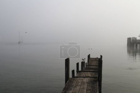 Téléchargez les photos : Quai bateau en bois avec le soleil du matin dans la brume - en image libre de droit