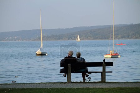 Foto de Dos personas mayores en un banco con vistas al lago Ammersee en Baviera - Imagen libre de derechos