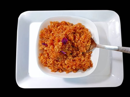 Téléchargez les photos : Le Gajar ka halwa est un dessert sucré indien à base de carotte, servi dans un bol. Garni de noix de cajou, d'amandes et de pistaches. - en image libre de droit
