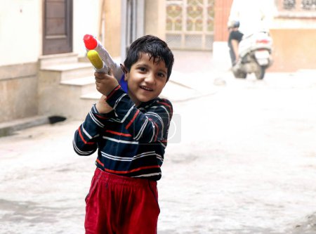 Téléchargez les photos : Mars 20222, Hisar, Haryana : Enfants indiens célébrant Holi avec des couleurs et des pichkari pendant le festival Holi - en image libre de droit