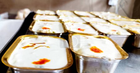 Sweet Rabdi or Rabri made with pure milk garnished with kesar. Served in a bowl over moody background at sweet shop. Selective focus